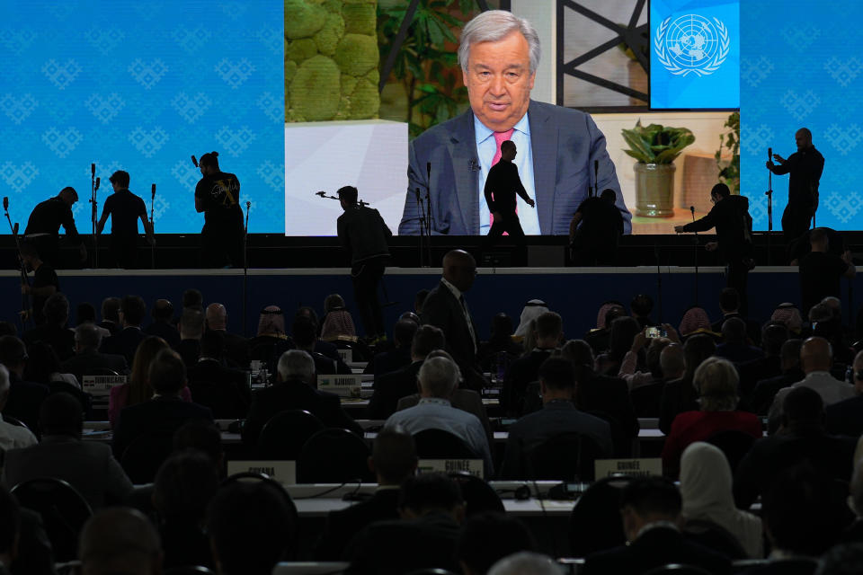 FILE - Participants watch a recorded message from United Nations Secretary-General Antonio Guterres during the opening session of The International Telecommunication Union (ITU), in Bucharest, Romania, Sept. 26, 2022. The head of the United Nations urged world leaders to take “credible” new action to curb climate change, warning that efforts so far fall short of what’s needed to avert catastrophe. (AP Photo/Vadim Ghirda, File)