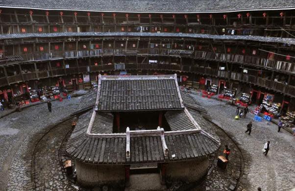 Los visitantes caminan <b>dentro de una Fujian Tulou de 700 años</b>, en el condado de Nanjing en China. Este tipo de construcciones han servido al pueblo hakka para defenderse de sus enemigos desde el siglo XI. (REUTERS/Stringer).