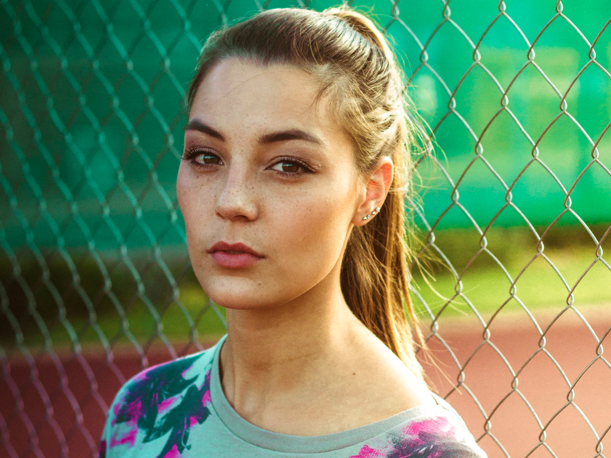 young woman outside thinking looking at camera