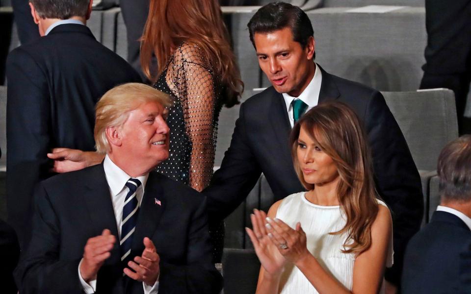 Mexican President Enrique Pena Nieto talks to US President Donald Trump and his wife Melania Trump at the G20 - Credit: Getty
