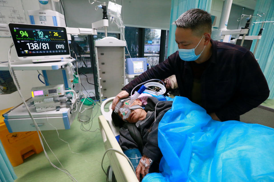 A relative attends to a Covid patient at the emergency department of Suining Central Hospital in Suining, Sichuan province on NYE. 