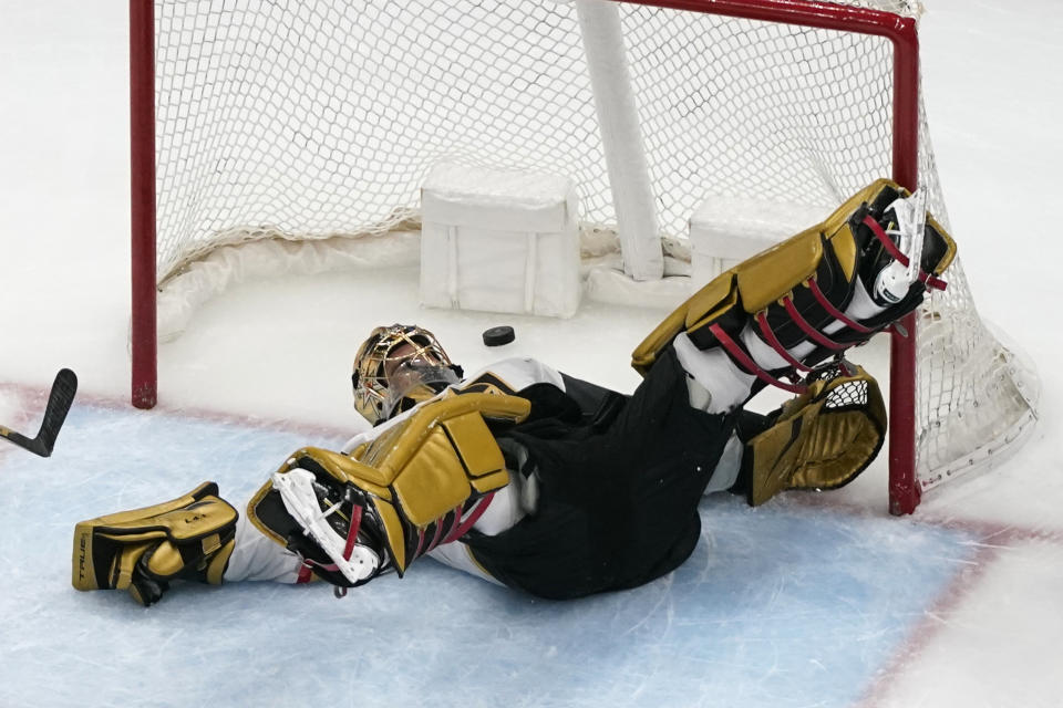 Vegas Golden Knights goaltender Marc-Andre Fleury slips as a puck flies by during the third period of an NHL hockey game against the St. Louis Blues Wednesday, April 7, 2021, in St. Louis. (AP Photo/Jeff Roberson)