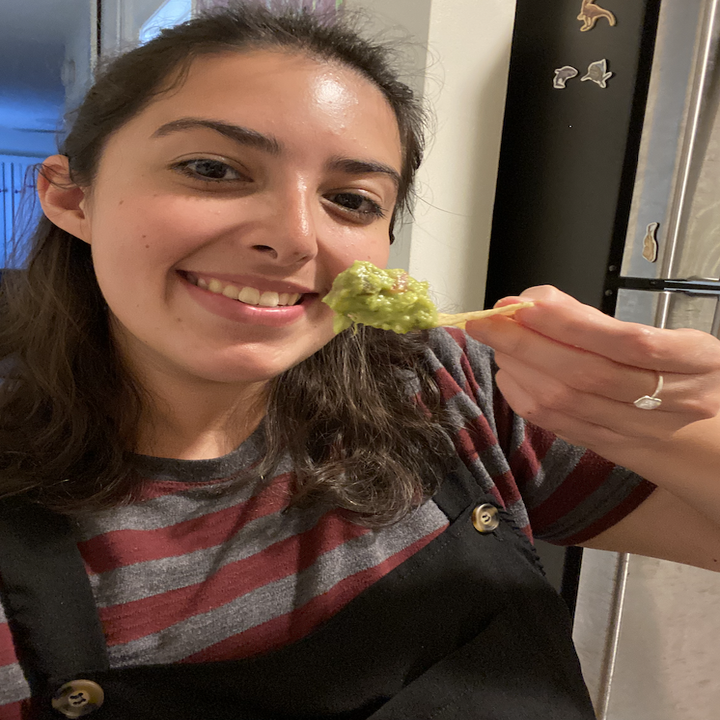 Person holding chip with guacamole