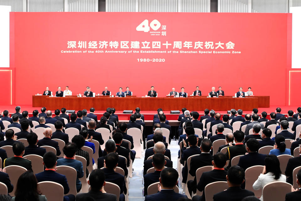In this photo released by China's Xinhua News Agency, Chinese President Xi Jinping, center, and other leaders applaud during an event to commemorate the 40th anniversary of the establishment of the Shenzhen Special Economic Zone in Shenzhen in southern China's Guangdogn Province, Wednesday, Oct. 14, 2020. Xi promised Wednesday new steps to back development of China's biggest tech center, Shenzhen, amid a feud with Washington that has disrupted access to U.S. technology and is fueling ambitions to create Chinese providers. (Zhang Ling/Xinhua via AP)