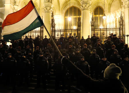 Policemen stand guard as people attend a protest against the new labour law in front of the Parliament building in Budapest, Hungary, December 13, 2018. REUTERS/Bernadett Szabo