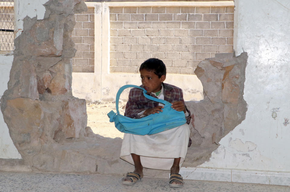 A boy sits in a hole in a school wall that was damaged in the ongoing conflict in Saada governorate on March 14, 2017. (Photo: STRINGER/AFP/Getty Images)