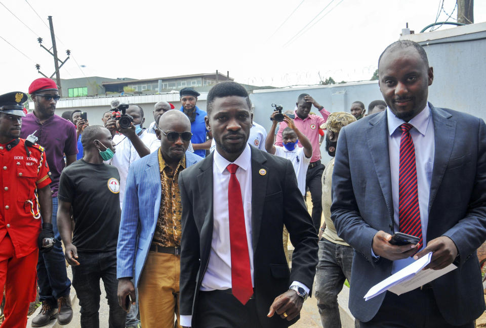 Bobi Wine, center, a singer and lawmaker whose real name is Kyagulanyi Ssentamu, arrives to speak at the National Unity Platform (NUP) head office in the Kamwokya suburb of Kampala, Uganda Monday, Aug. 31, 2020. Bobi Wine, who spoke on Monday to answer questions swirling around his age and academic record, cited "a pattern of repression and suppression" aiming to derail his bid against the long-time president Yoweri Museveni in polls scheduled for 2021. (AP Photo/Ronald Kabuubi)