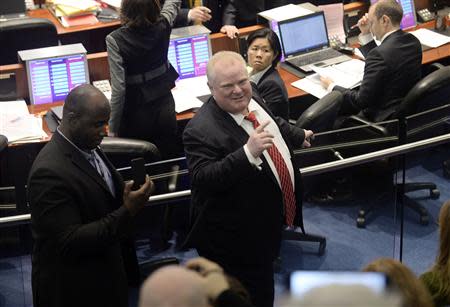 Toronto Mayor Rob Ford (R) walks around council chambers while an unidentified member of his staff captures images of the public gallery during a special council meeting at City Hall in Toronto November 18, 2013. REUTERS/Aaron Harris