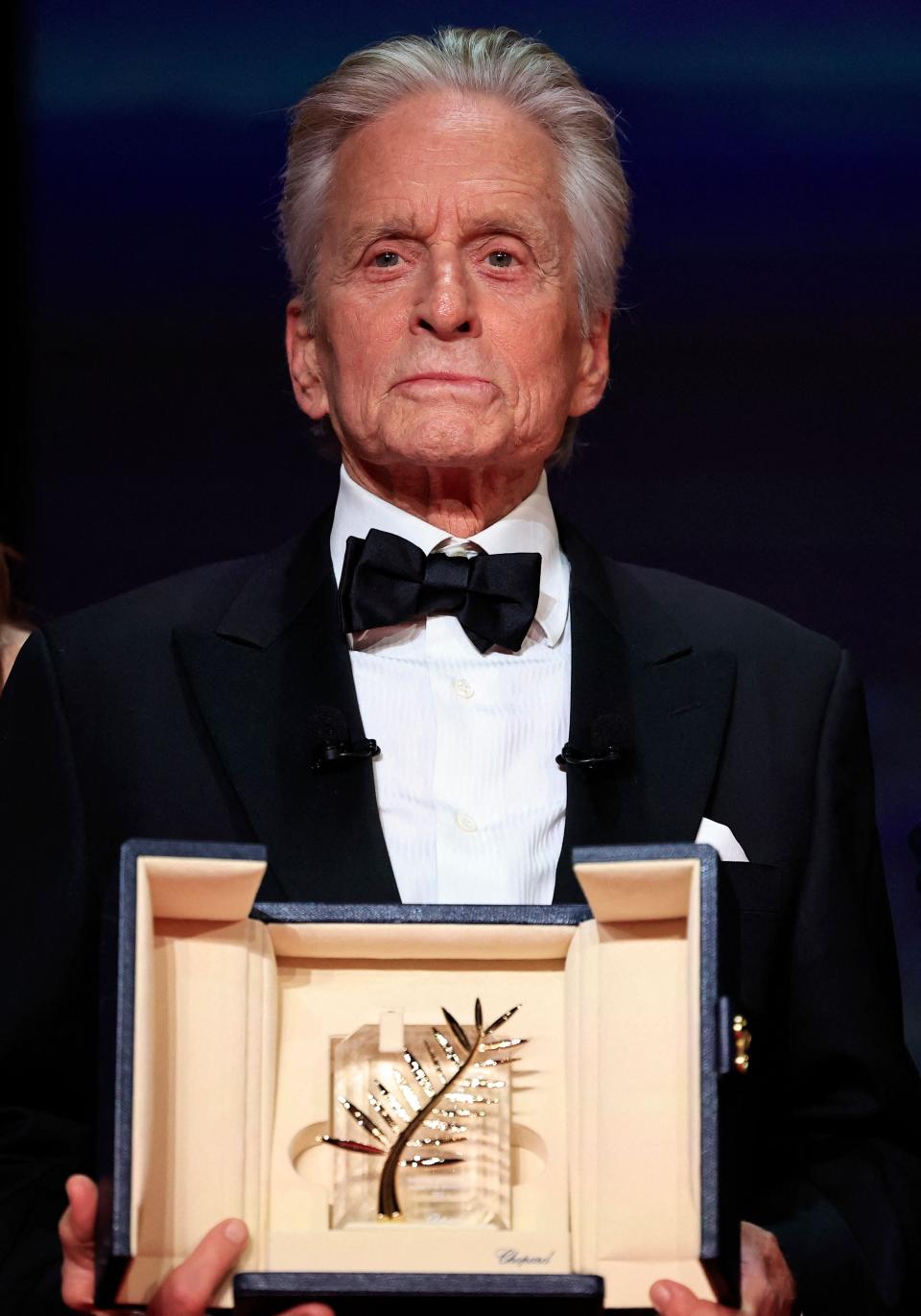 Michael Douglas poses with his Honorary Palme d'Or at the opening ceremony of the Cannes Film Festival.