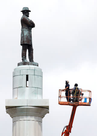 Construction crews prepare a monument of Robert E. Lee, who was a general in the Confederate Army, for removal in New Orleans, Louisiana, U.S., May 19, 2017. REUTERS/Jonathan Bachman