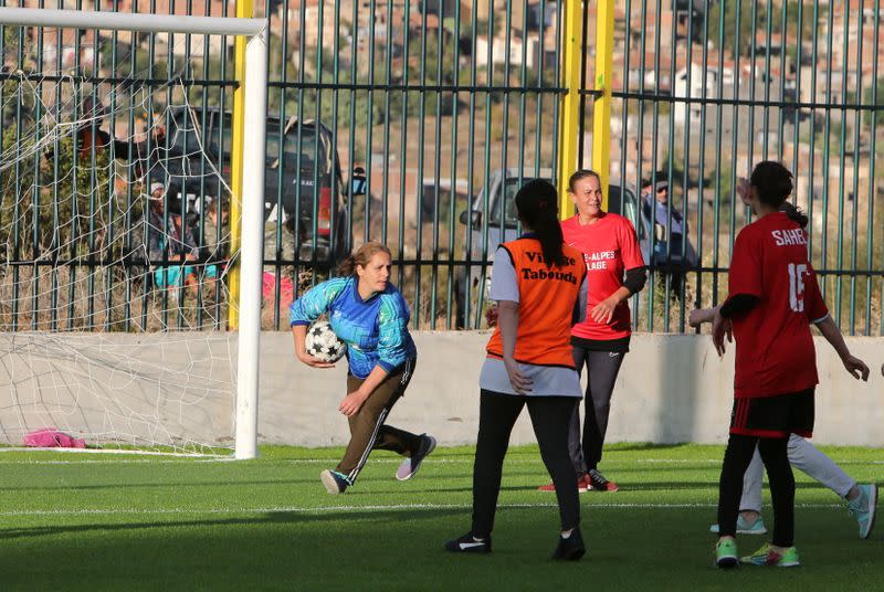 Aida, 41, carries the ball during a match in an annual local soccer tournament in the village of Sahel