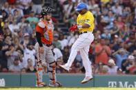 Boston Red Sox's Rafael Devers, right, celebrates in front of Baltimore Orioles' Austin Wynns after scoring on a single by Xander Bogaerts during the fifth inning of a baseball game, Saturday, Sept. 18, 2021, in Boston. (AP Photo/Michael Dwyer)