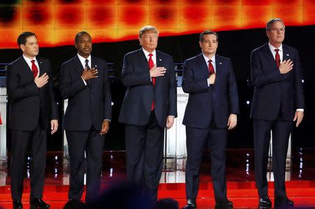 Republican U.S. presidential candidates (L-R) Senator Marco Rubio, Dr. Ben Carson, businessman Donald Trump, Senator Ted Cruz and former Governor Jeb Bush hold their hands over their hearts for the singing of the U.S. national anthem before the start of the Republican presidential debate in Las Vegas, Nevada December 15, 2015. REUTERS/Mike Blake