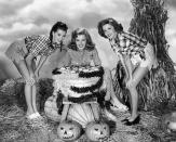 <p>As fashion began to evolve and leg-baring became apropo, so did Halloween costumes. Here, three actresses dressed as "girls on the farm" bob for apples. </p>