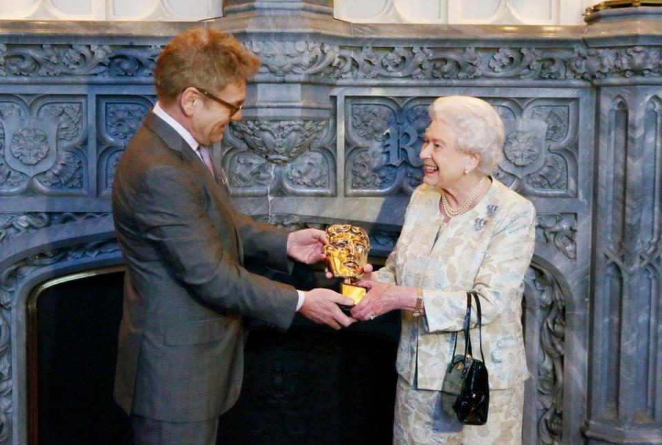 The Queen receives an honorary Bafta from Sir Kenneth Branagh for a lifetime’s support of British film and television in 2013 (Steve Parsons/PA) (PA Archive)