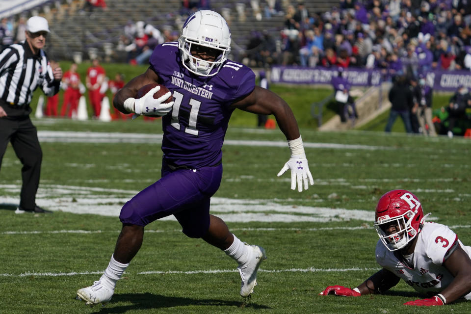 Northwestern running back Andrew Clair, left, runs with the ball past Rutgers linebacker Olakunle Fatukasi during the second half of an NCAA college football game in Evanston, Ill., Saturday, Oct. 16, 2021. Northwestern won 21-7. (AP Photo/Nam Y. Huh)