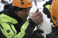 A firefighter kisses one of the three puppies that were found alive in the rubble of the avalanche-hit Hotel Rigopiano, near Farindola, central Italy, Monday, Jan. 22, 2017. Emergency crews digging into an avalanche-slammed hotel were cheered Monday by the discovery of three puppies who had survived for days under tons of snow, giving them new hope for the 23 people still missing in the disaster. (Italian Firefighters via AP)