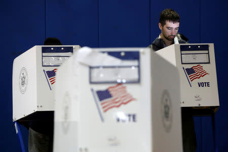 A man fills out a voting ballot at P.S. 20 during the midterm election in Manhattan in New York City, U.S., November 6, 2018. REUTERS/Andrew Kelly