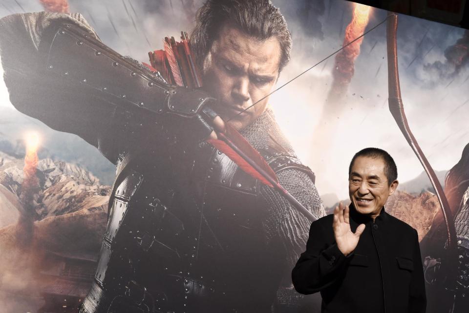 Zhang Yimou, director of "The Great Wall," poses in front of a poster featuring star Matt Damon at the premiere of the film at the TCL Chinese Theatre on Wednesday, Feb. 15, 2017, in Los Angeles. (Photo by Chris Pizzello/Invision/AP)