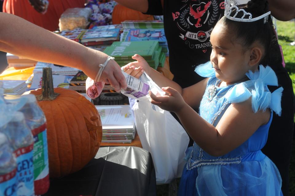 (10/27/2021) Sophala Keo, 5, made her way down Sierra Vista's Harvest Festival trick-or-treat stations with her mom as she received candy, books, snacks and more in South Stockton on Oct. 27, 2021. LAURA S. DIAZ / THE STOCKTON RECORD.