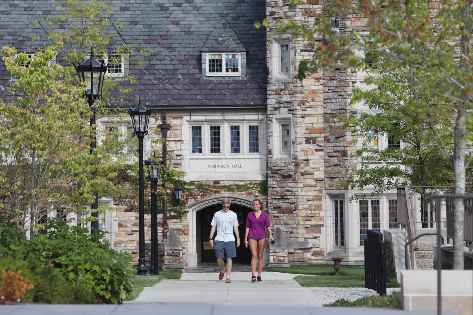 Students walk away from the Robinson Hall dormitory on the Rhodes College campus in Memphis, Tenn.
