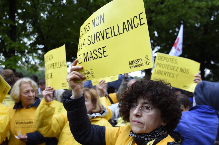 French protesters hold placards reading "Say no to mass surveillance" as they demonstrate in paris, on May 4, 2015