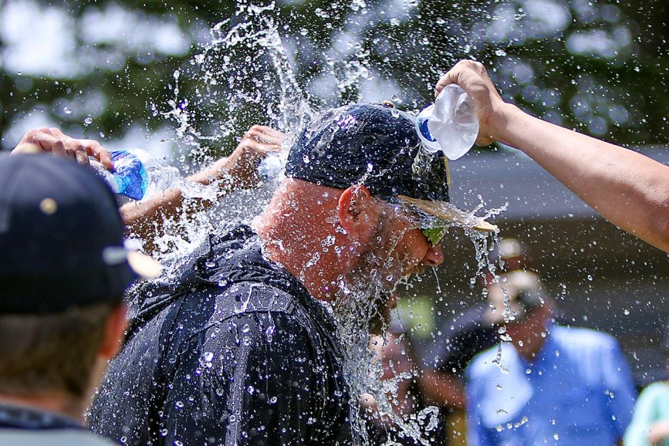 Galesburg head coach Jeremy Pickrel reacts to getting soaked with cold water during a celebration after the Silver Streaks' 10-0 win over Streator in the Class 3A regional championship game on Saturday, May 28, 2022.