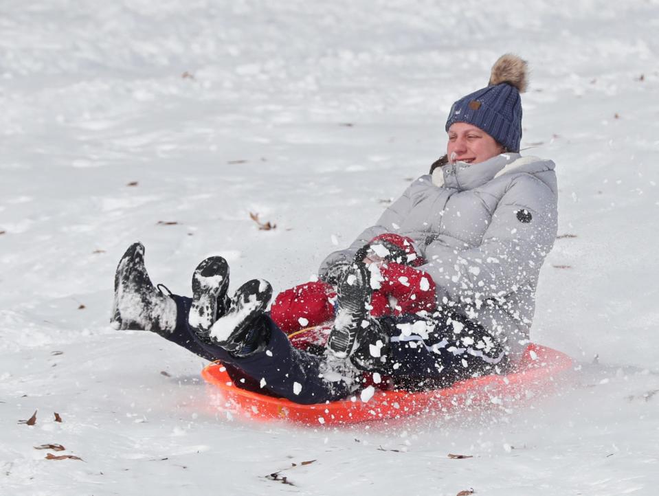 Carrie Huck of Tallmadge and her son Jordan, 6, kick up some snow as they come down the sledding hill Jan. 18 at Goodyear Heights Metro Park in Akron.