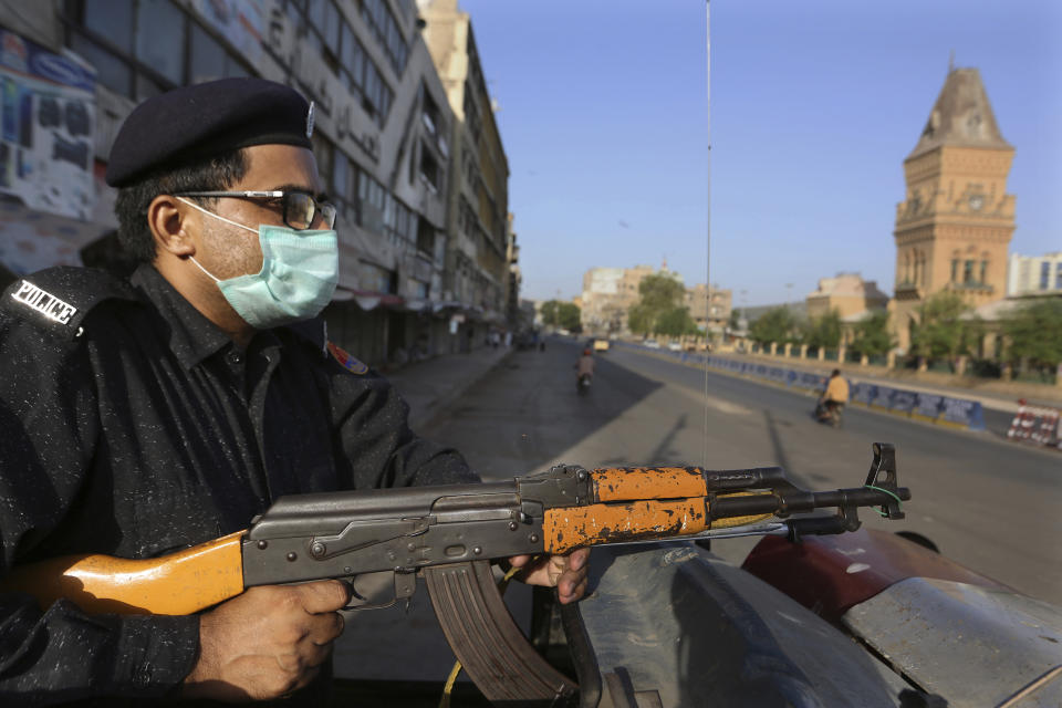 A police officer stands guard in a business district to ensure a lockdown to help control the spread of the coronavirus, in Karachi, Pakistan, Sunday, May 9, 2021. (AP Photo/Fareed Khan)