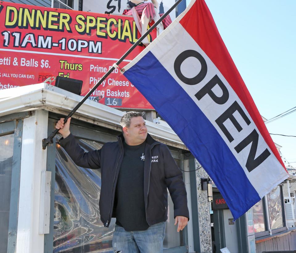 L Street co-owner Jake Magro adjusts the open flag as it got tangled in the wind on Feb. 26, 2024. Magro and his staff had to deal with confusion and concern from customers after a website published a story that said the tavern was closing.