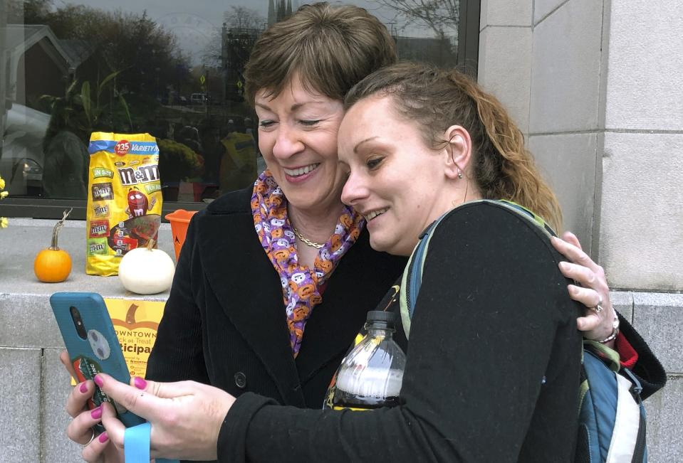 In this Friday, Oct. 25, 2019 photo, U.S. Sen. Susan Collins, R-Maine, poses for a selfie with Tessa Morin outside her office during a trick-or-treat event hosted by the local chamber of commerce in Lewiston, Maine. Collins is expected to make a formal announcement on her reelection plans later this fall. (AP Photo/David Sharp)