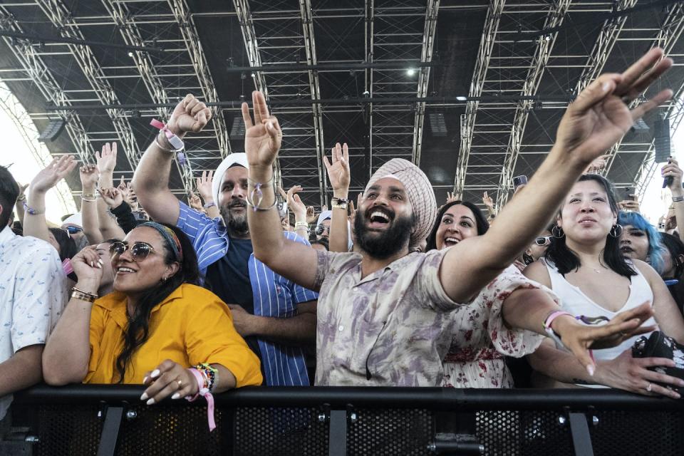 Festival-goers smiling at the front of a show at Coachella Valley Music and Arts Festival at the Empire Polo Club on April 22, 2023, in Indio, Calif. (Photo by Amy Harris/Invision/AP)