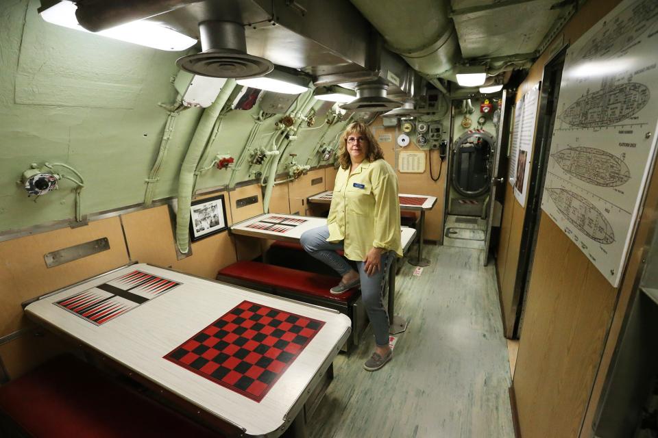 Patricia Violette-Adams, executive director of Albacore Park gives a look inside the submarine in Portsmouth Monday, May 22, 2023. This is where sailors ate, studied, played games and even had movie nights.