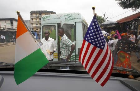 The U.S. (R) and Ivory Coast national flags are displayed in a public transport bus in Abidjan August 3, 2014. REUTERS/Luc Gnago