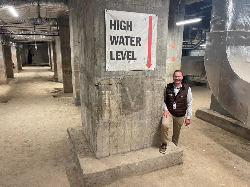 Austin Giesey, project manager for the Christman/Brinker Corktown Transformation Joint Venture, stands in the basement of Michigan Central Station on May 15, 2024. The sign shows the high water mark in the basement when Ford Motor Co. purchased the building in 2018.