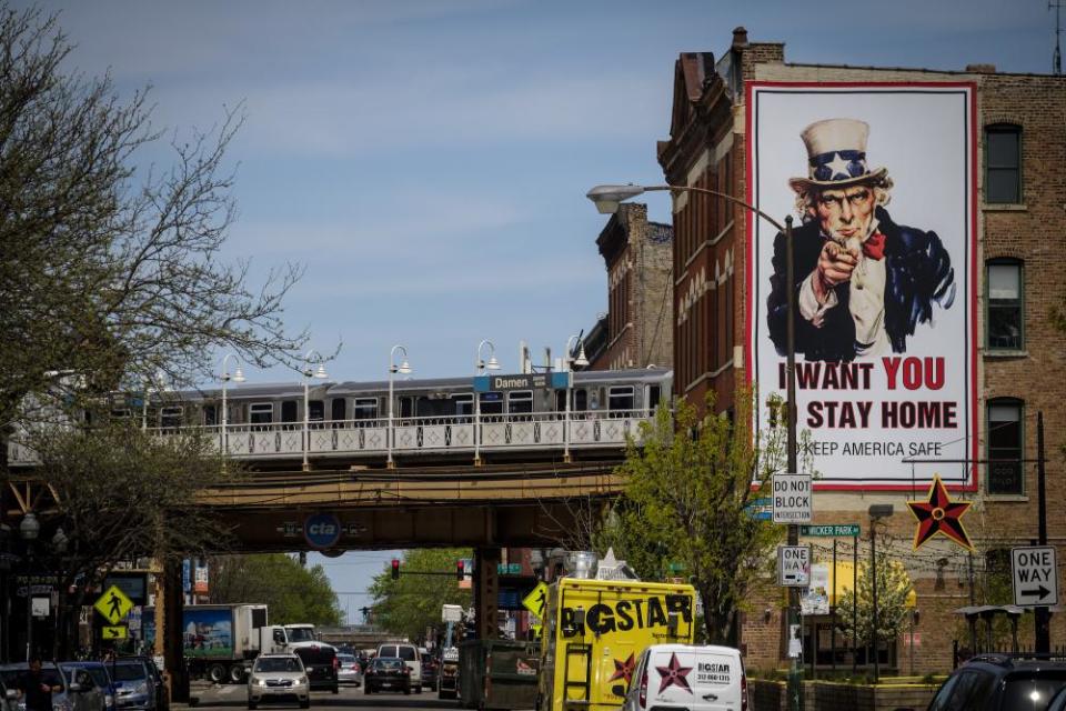 A L train passes an “I Want You To Stay Home” billboard in Chicago, Illinois, U.S., on Thursday, May 7, 2020. Governor Pritzker extended the state’s stay-at-home order through the end of May, but he loosened restrictions on certain outdoor activities starting May 1.