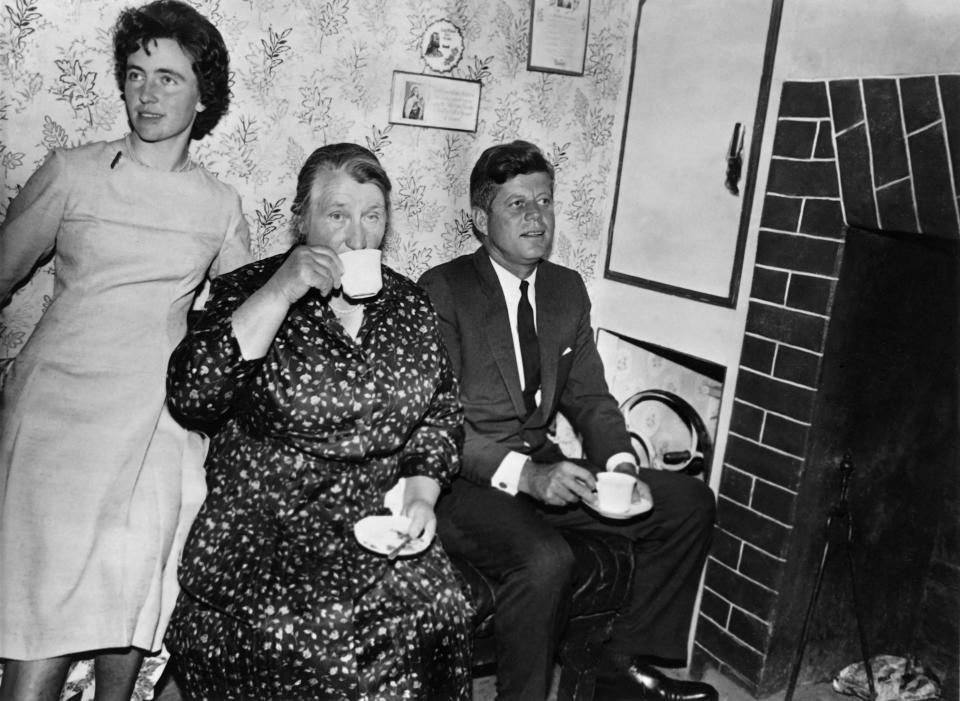 U.S. President John Fitzgerald Kennedy takes tea with his Irish cousin Mary Ryan (C) and her daughter Mary Anne (L) in their great-grandfather's house in Dunganstown, County Wexford, on June 28, 1963.