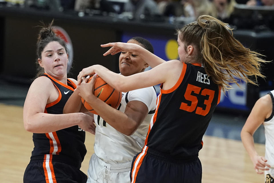 Colorado forward Quay Miller, center, struggles to control a rebound as Oregon State forwards Raegan Beers, left, and Kelsey Rees (53) defend in the second half of an NCAA college basketball game Sunday, Feb. 11, 2024, in Boulder, Colo. (AP Photo/David Zalubowski)