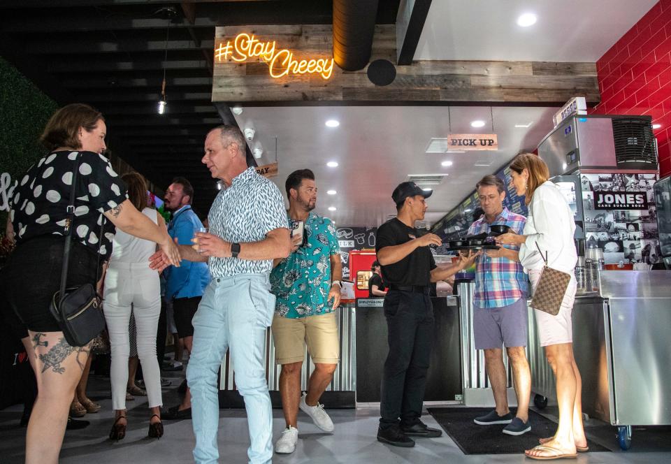 Guests mingle and try samples during a VIP grand opening celebration at I Heart Mac & Cheese in Palm Springs, Calif., Tuesday, June 28, 2022. 