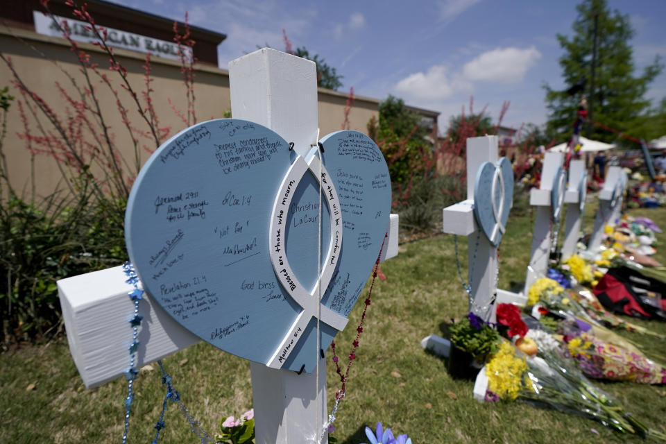 A cross with a name on it, and notes left by visitors, stands by others at a makeshift memorial by the mall where several people were killed in Saturday's mass shooting, Monday, May 8, 2023, in Allen, Texas. (AP Photo/Tony Gutierrez)