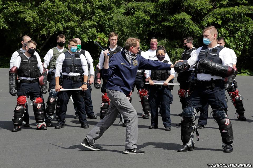 In this June 4, 2020 photo, Christopher Clarke, front left, an instructor at the Washington state Criminal Justice Training Commission facility in Burien, Wash., teaches a class on the use of batons to law enforcement officers as part of the more than 700 hours of training police and other officers are required to go through in the state. Police training has been under scrutiny again since the death of George Floyd, a black man who died after being restrained by Minneapolis police officers.