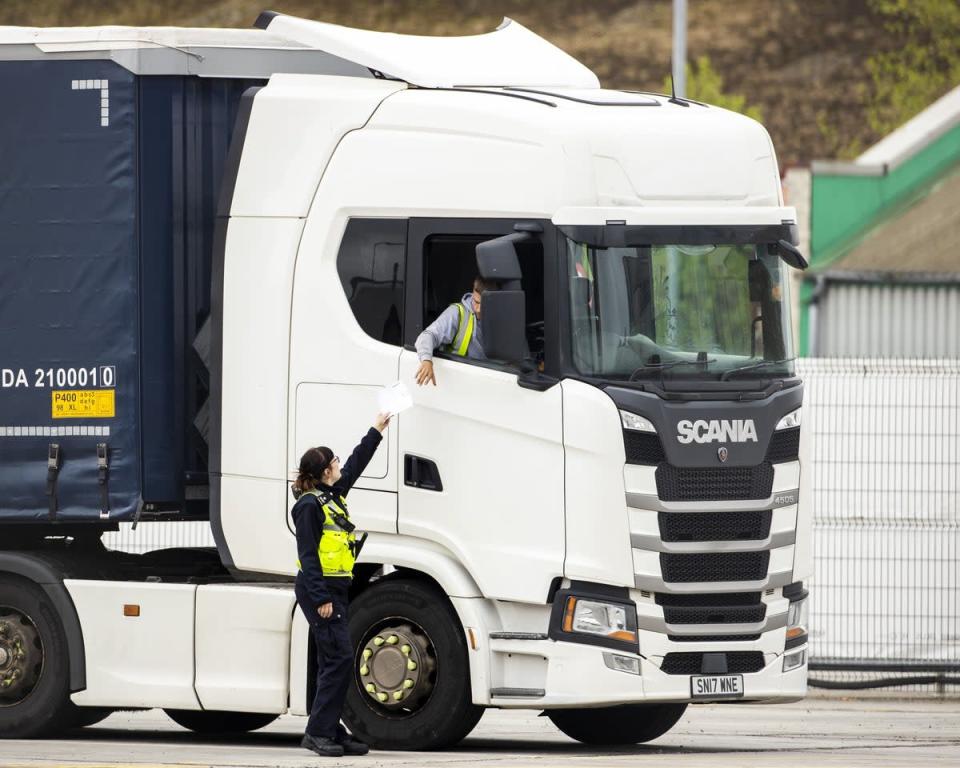 A Border Force Officer returns papers to a haulage driver at a checking facility at Belfast Port (PA) (PA Wire)
