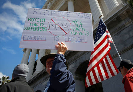 Protestors hold signs during a "March For Our Lives" demonstration demanding gun control in Sacramento, California, U.S. March 24, 2018. REUTERS/Bob Strong