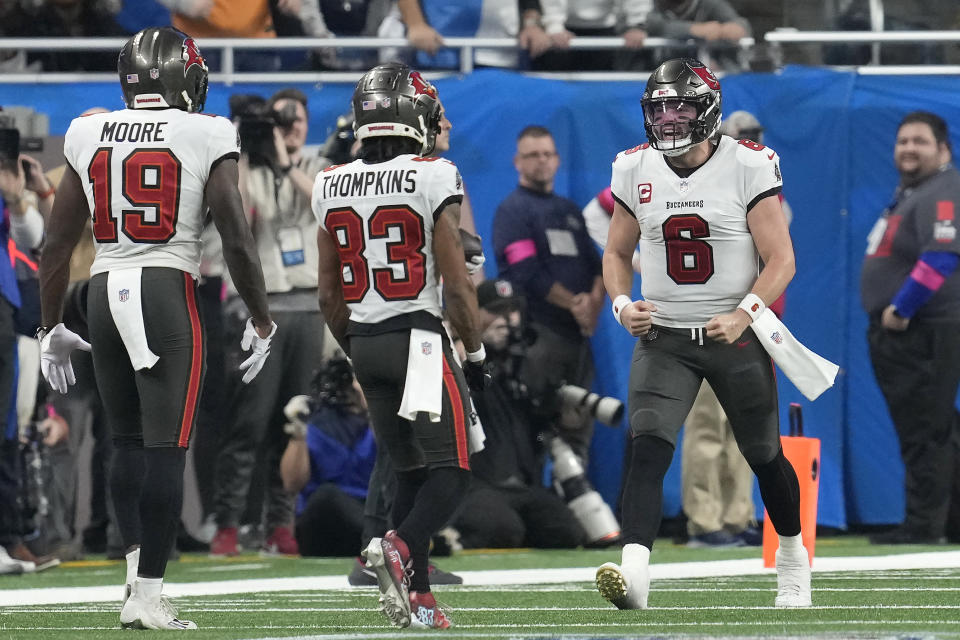 Tampa Bay Buccaneers quarterback Baker Mayfield (6) celebrates with wide receiver David Moore (19) and wide receiver Deven Thompkins (83) after throwing a touchdown pass to tight end Cade Otton, not visible, during the first half of an NFL football NFC divisional playoff game against the Detroit Lions, Sunday, Jan. 21, 2024, in Detroit. (AP Photo/Paul Sancya)
