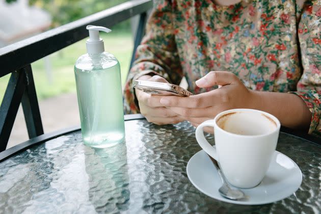 Close-Up of Female Hands is Using Mobile Phone While Waiting for Coffee Order in Cafe Shop During Covid-19 Pandemic Situation. (Photo: KDP via Getty Images)