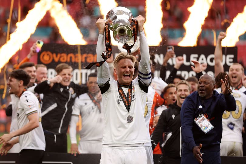 Byron Webster of Bromley celebrates with the trophy after winning the Vanarama National League Play-Off Final match between Bromley and Solihull Moors at Wembley Stadium on May 05, 2024 in London