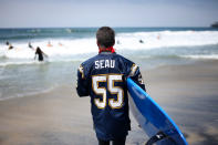 OCEANSIDE, CA - MAY 6: A surfer prepares go out into the surf for a ceremony during a "paddle-out" in honor of NFL star Junior Seau on May 6, 2012 in Oceanside, California. Seau, who played for various NFL teams including the San Diego Chargers, Miami Dolphins and New England Patriots was found dead in his home on May 2nd of an apparent suicide. Family members have decided to donate his brain for research on links between concussions and possible depression. (Photo by Sandy Huffaker/Getty Images)