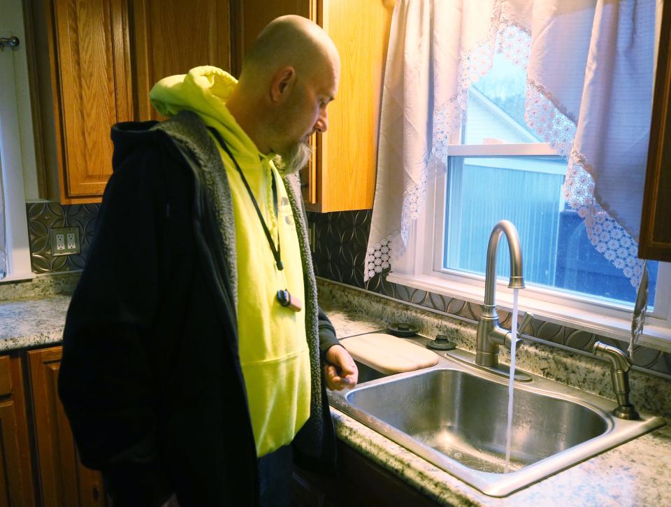 Ronnie Johnson turns on the water at his house he is trying to sell to see if the water looks or smells.