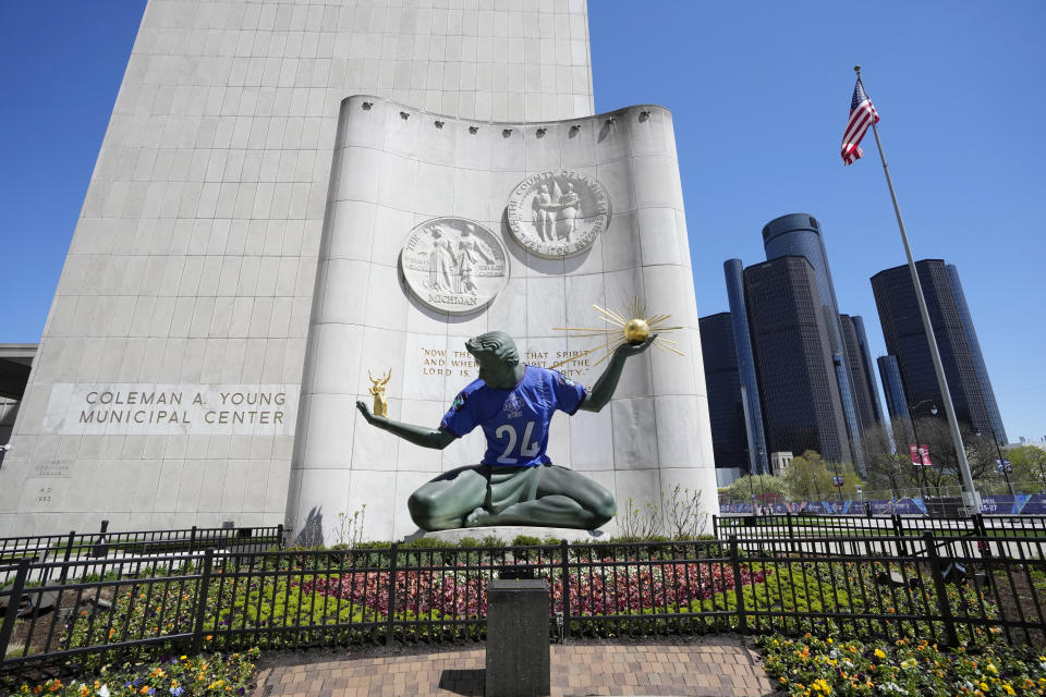 An NFL football draft jersey is displayed on the Spirit of Detroit statue Friday, April 19, 2024, in Detroit. The draft has taken the show on the road for a decade, giving cities a chance around the country a chance to be in the spotlight. The Motor City, which was once one of the nation's largest and most powerful cities, has bounced back from filing for bankruptcy in 2013. (AP Photo/Carlos Osorio)