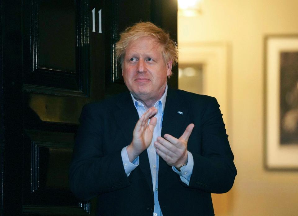 In this Thursday, April 2, 2020 handout photo provided by 10 Downing Street, Britain's Prime Minister Boris Johnson claps outside 11 Downing Street to salute local heroes during Thursday's nationwide Clap for Carers NHS initiative to applaud workers fighting the coronavirus pandemic, in London.